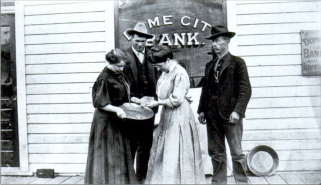 Belinda Mulrooney (center) in front of her Dome City Bank, inspecting an 88-ounce nugget, together with her sister Margaret Mulrooney, Miller Thosteseu and Jack Tobin. The photo was taken around 1905.