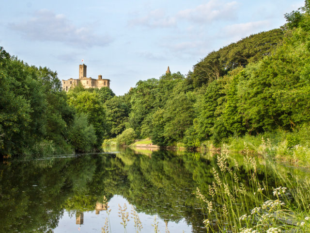 View of the castle from the Coquet river Photo Credit
