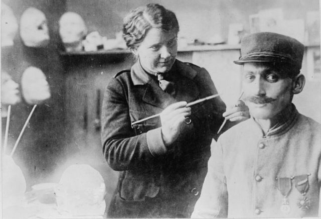 Ladd working on a mask with a soldier in her studio.