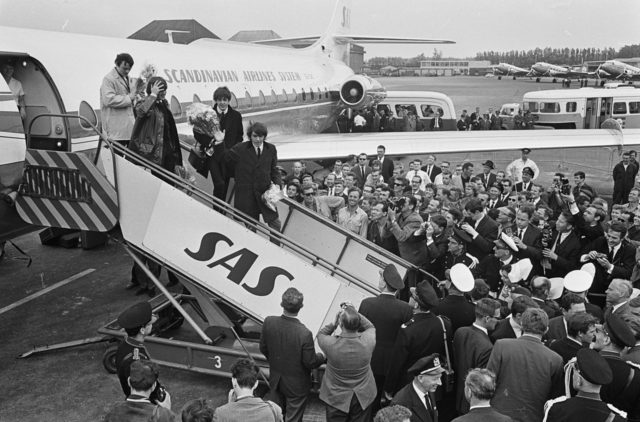 Beatlemania: Fans and media swarm the Beatles at Schiphol Airport in Amsterdam, 1964. Photo Credit