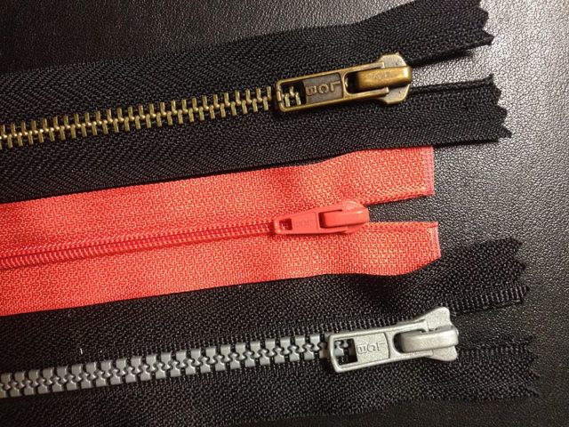 Zippers with common teeth variations: from top, metal teeth, coil teeth, and plastic teeth. Photo Credit