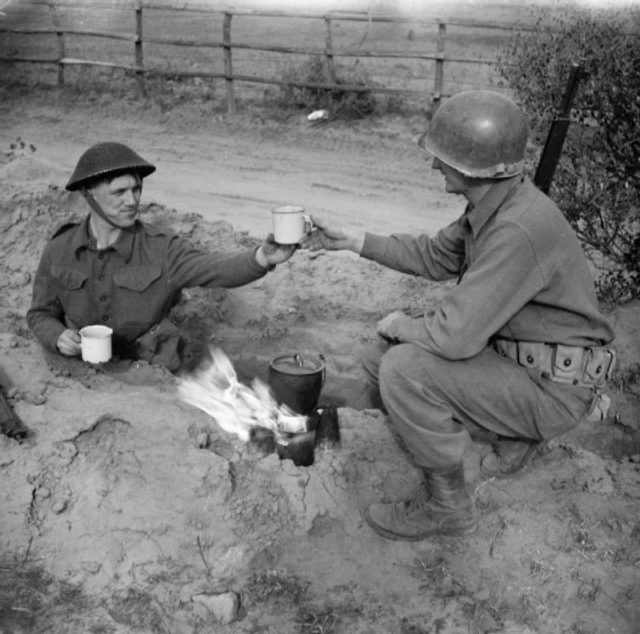 A British soldier with the 2/7th Middlesex Regiment shares a cup of tea with an American infantryman in the Anzio bridgehead, Feb. 10, 1944