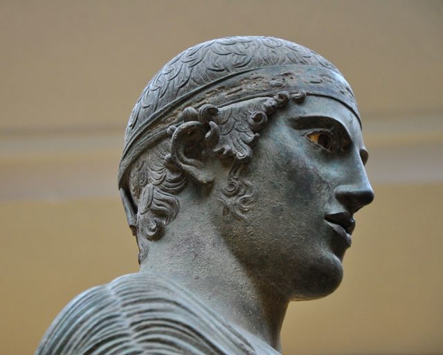 The Charioteer’s introverted expression is compared with the Archaic smile. Author: Helen Simonsson. CC BY-SA 3.0