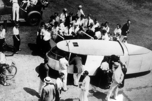 The Dymaxion car, c.1933. Artist Diego Rivera is shown entering the car, carrying a coat. Author Sascha Pohflepp, CC – BY 2.0