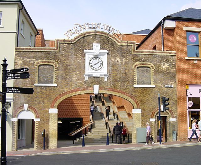 Fremlin Walk, Earl Street. The old gate to Fremlin’s Brewery, reused as an entrance to a shopping center now occupying the venue. The brewery’s elephant logo can be seen above the clock. Author: Penny Mayes, CC BY-SA 2.0