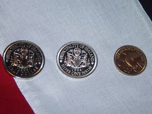 Sealandic coins, from left to right: half dollar, silver one dollar, and quarter dollar