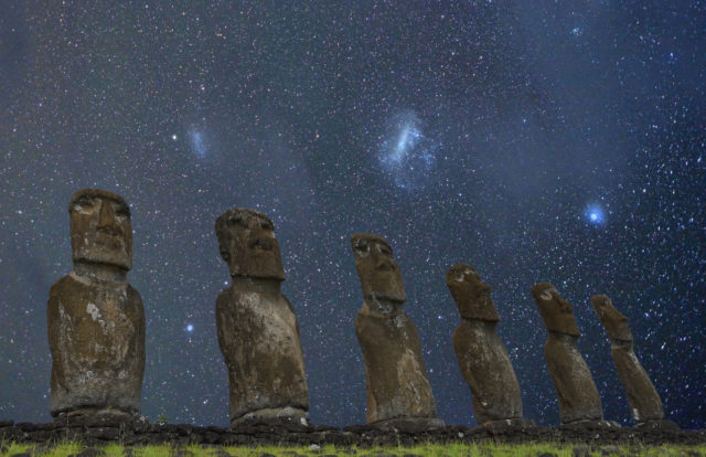 Easter Island moai stone statues under starry sky of the Southern Hemisphere. Clearly visible are galaxies called Small and Large Magellanic Clouds. iStock.com/andyKRAKOVSKI