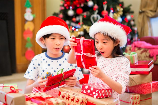Chinese siblings opening gifts for Christmas.