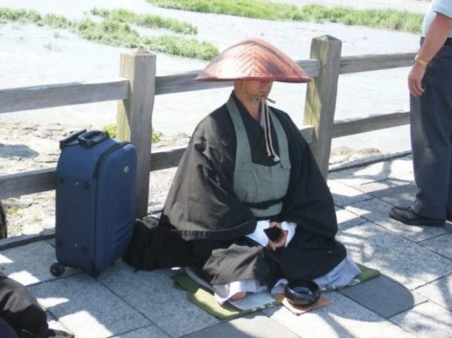 A Buddhist Monk sits in zazen meditation in Japan. Buddhist temples are handling the funerals of the deceased persons from the ships.