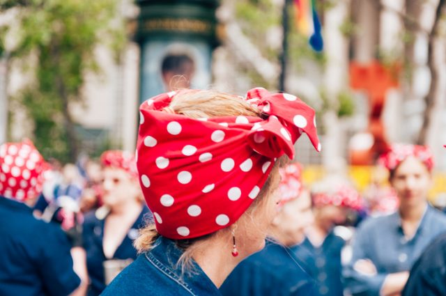 San Francisco, CA, USA – June 25, 2017: The 2017 Pride Parade the profile of a woman dressed like ‘Rosie the Riveter’ in sharp focus along with accompanying ‘Rosie the Riveter’ costumes in the background.