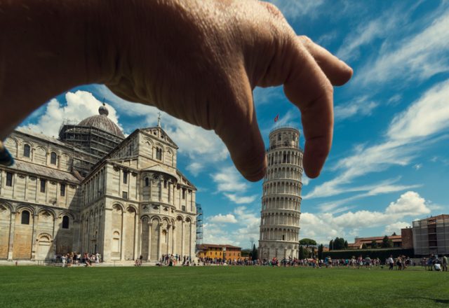 Pisa, Tuscany, Italy. Tourist visit the Pisa Tower. Dramatic Sky in summer. Hand hold the leaning Pisa tower.
