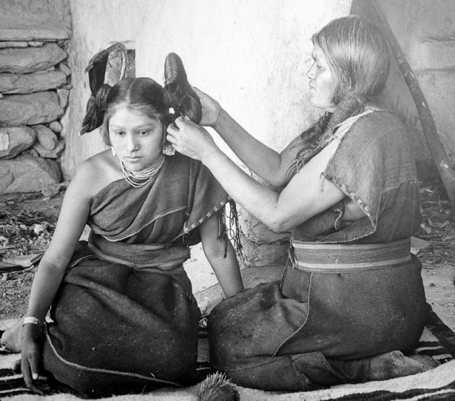 Hopi woman dressing hair of unmarried girl, c. 1900, photo by Henry Peabody