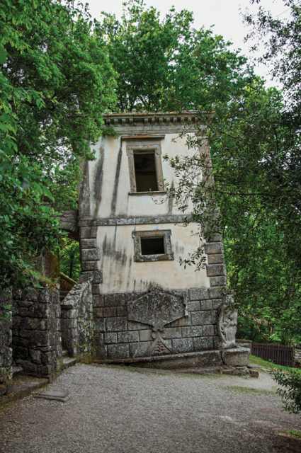 View of house amidst the vegetation in the Park of Bomarzo. Also known as Park of Monsters, it was created to surprise the visitor with surrealistic works in stone. Lazio region, central Italy