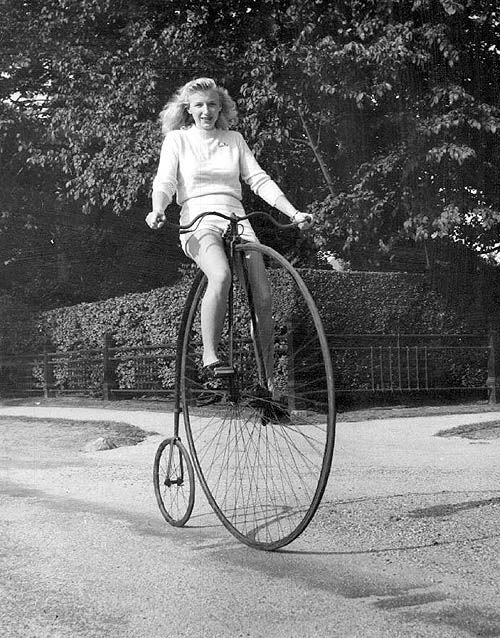 Woman riding a penny farthing, 1949
