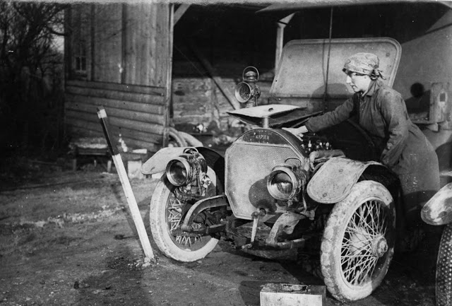 A member of the British First Aid Nursing Yeomanry oiling her car near the Western Front. (National Library of Scotland)