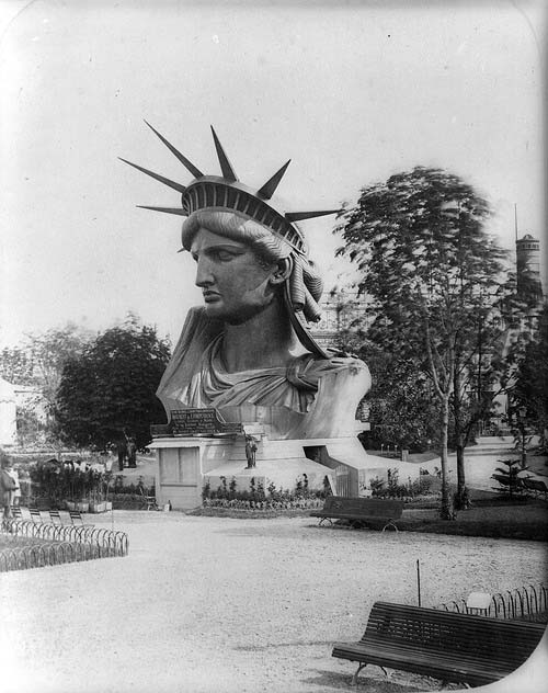 Passers-by marvel at the Statue of Liberty head as she goes on display before her dedication in New York 
