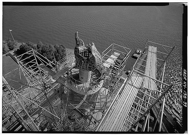 View looking down on torch and flame from top of scaffolding; ventilator cap has been removed from flame prior to removal of torch on July 4, 1984
