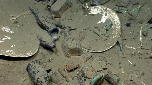 This photo provided by the NOAA Okeanos Explorer Program shows a variety of artifacts including ceramic plates, platters, bowls plus glass liquor, wine, medicine, and food storage bottles of many shapes and colors found inside a wrecked ship's hull. source