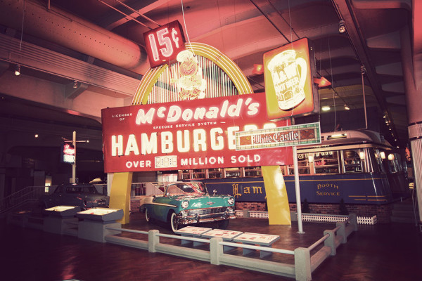 A 1956 Chevrolet Bel Air convertible is displayed in front of a vintage McDonald's neon sign at Henry Ford Museum. source
