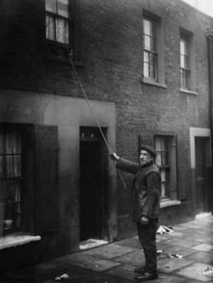 A knocker up with his pole tapping a window. source