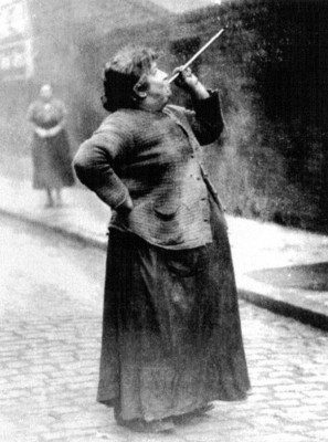 A knocker-upper shooting dried peas at the windows of her sleeping clients. source