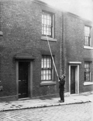 The knocker-upper used a truncheon or short, heavy stick to knock on the clients’ doors or a long and light stick, often made of bamboo, to reach windows on higher floors. source