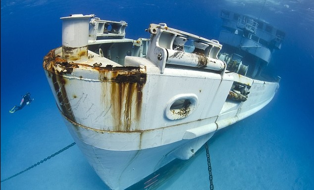 A diver approaches the bow of the Kittiwake, a US military ship purposely sunk off the Cayman Islands for divers to explore. Photo credit Alexander Mustard 