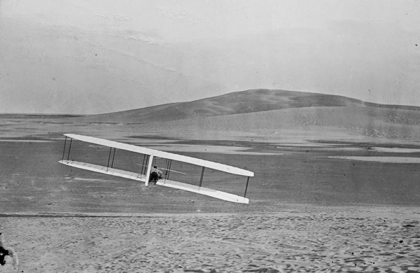 Rear view of Wilbur making a right turn in a glide from No. 2 Hill, right wing tipped close to the ground, October 24, 1902.