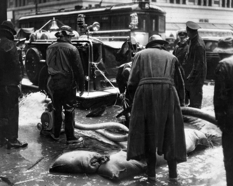 March 2, 1938 Water rising above the drain level in underground conduits threatened telephone service in downtown Los Angeles. Fire Department pumpers answered the call.