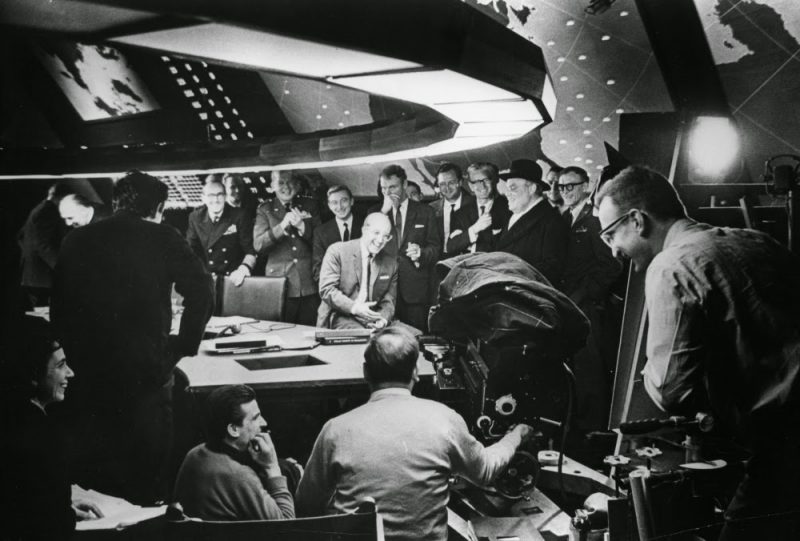 Peter Sellers (centre) shares a joke with cast and crew in Ken Adam’s famous war room set.