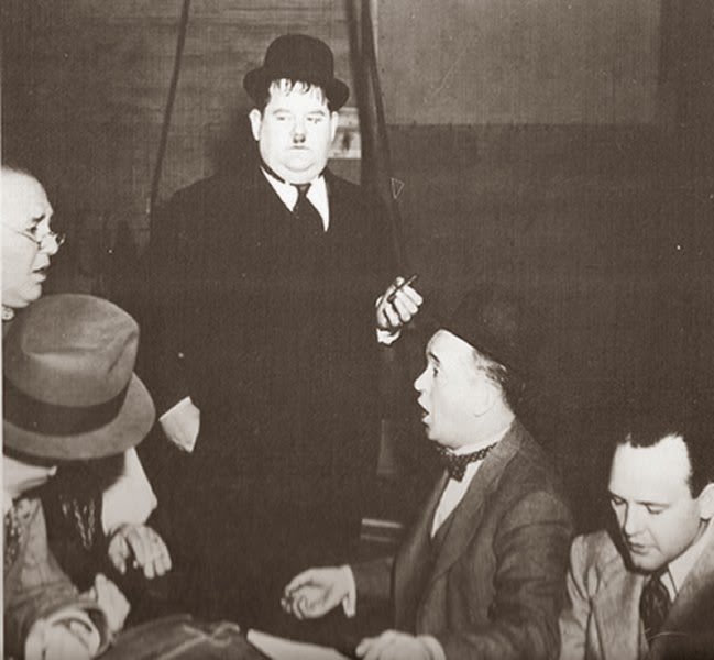 Stan Laurel singing with Marvin Hatley Charles Judels while Babe Hardy looks on.