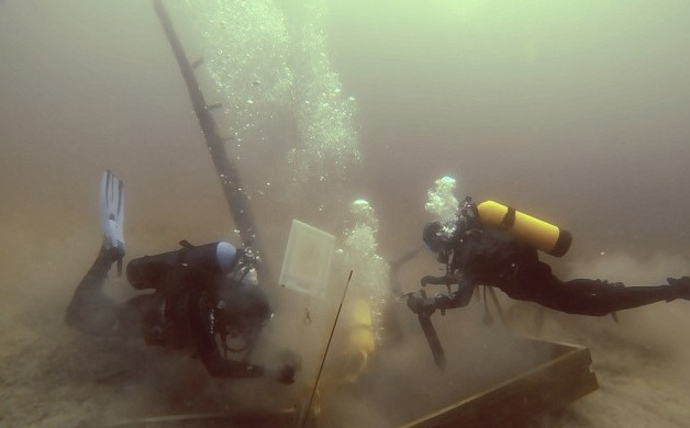 Divers inspect a hole being dug beside a wooden beam jutting from the floor of Lake Michigan during exploration for the 17th century ship the Griffin. source AP 