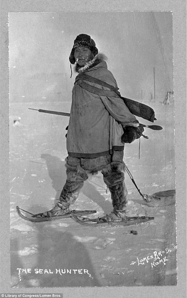 A seal hunter is seen walking on land, his snow shoes helping him easily slide across the frozen land