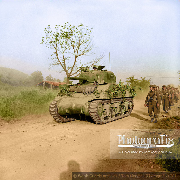 Guardsmen from the 3rd Battalion Welsh Guards are passed by a Sherman tank of 26th Armoured Brigade as they move forward to attack Monte Piccolo outside Arce, Italy, 27 May 1944.