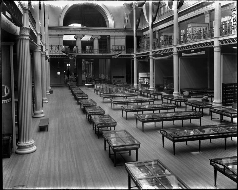 East court. Archaeology and Ethnology of North America. Large canoe and other canoes hanging in front of alcoves. Exhibits and floor cases, 1897