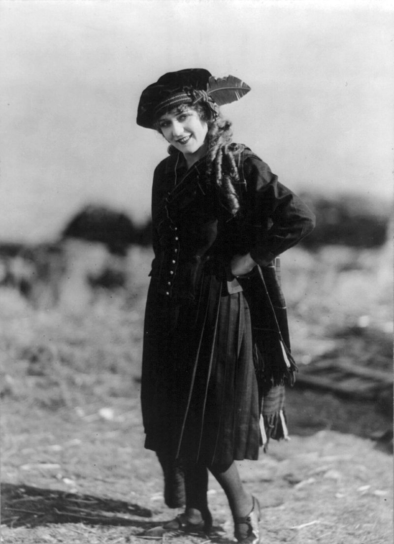 Mary Pickford, full-length, standing, facing left, left hand on hip.Source