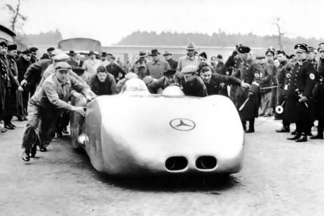 Bern Swiss GP August 1938 – Sitting on a plinth in front of the Heiliggeisit-Kirche (Church of the Holy Ghost) on the Bahnhofplatz in Bern is the 736 bhp V12 Mercedes Benz record car in which Caracciola had achieved 268 mph (436 kmh) on the Frankfurt/Darmstadt autobahn during the Rekordwoche on January 28, 1938. This was a PR exercise for Mercedes-Benz preceding the Swiss GP. source