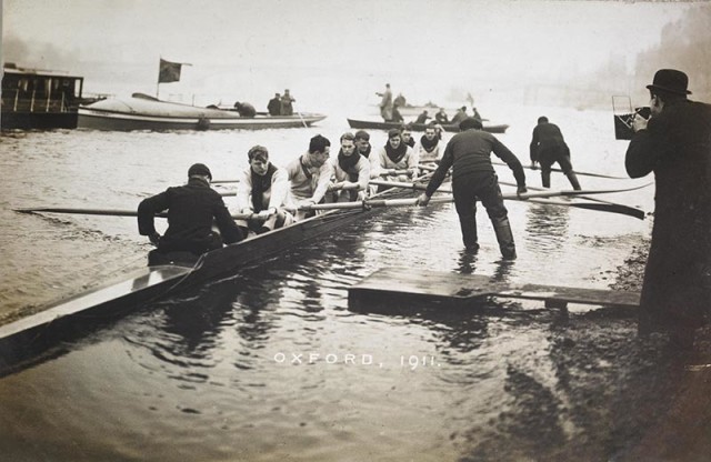 The Oxford rowing team at the University boat race, with photographer Alexander Korda at the water’s edge, Putney, 1911.