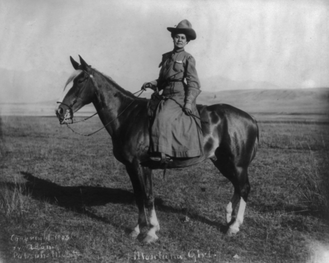 A Montana woman in cowgirl attire on horseback.