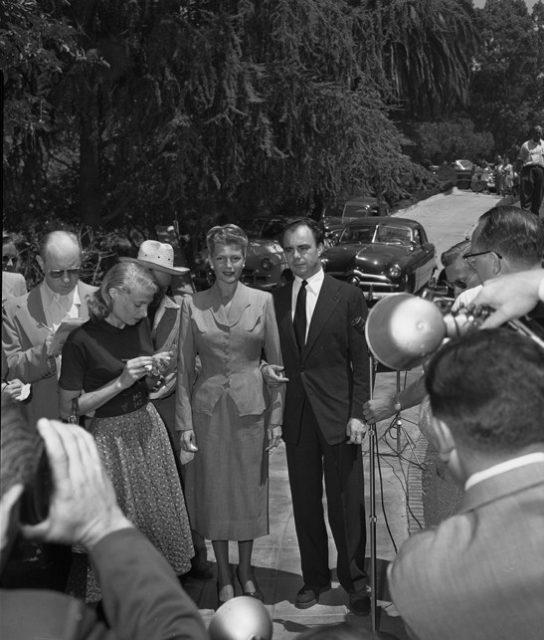 Rita Hayworth and estranged husband Aly Kahn surrounded by reporters outside Hayworth’s home, 1952.