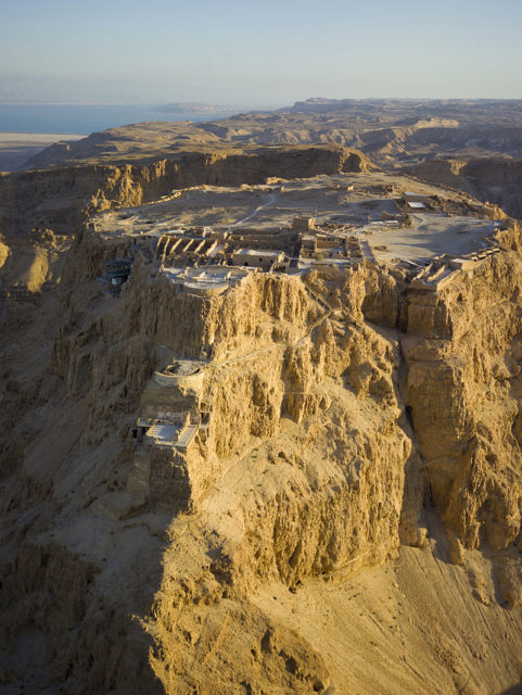 Aerial view of Masada, in the Judaean Desert, with the Dead Sea in the distance.