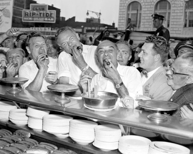 Governor Nelson Rockefeller, Henry Cabot Lodge and New York Attorney General Louis Lefkowitz gulp hot dogs at a Coney Island hotdog stand. (Photo by Seymour Wally/NY Daily News Archive via Getty Images)