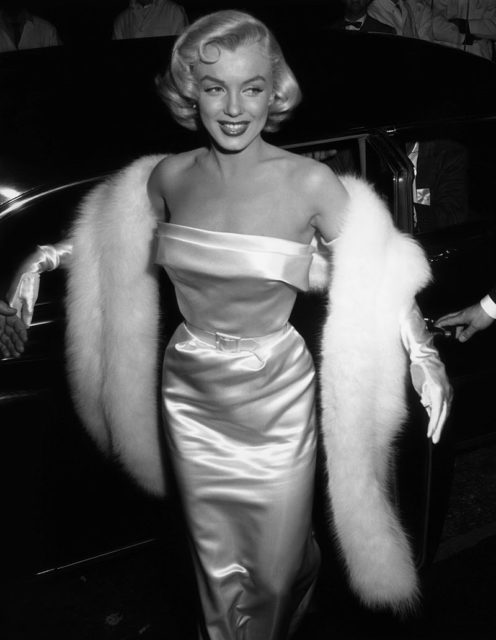 Marilyn Monroe, in a stunning white dress and fur coat.