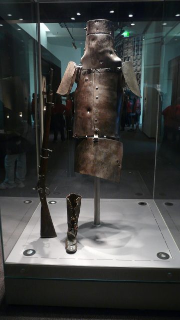Kelly’s armour on display in the State Library of Victoria. The helmet, breastplate, backplate and shoulder plates show a total of 18 bullet marks. Also on display are Kelly’s Snider Enfield rifle and one of his boots. Photo by Chensiyuan CC BY SA 4.0