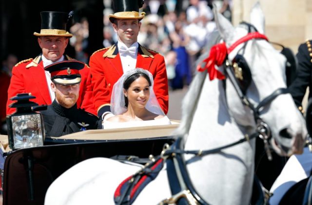 Prince Harry, Duke of Sussex and Meghan, Duchess of Sussex travel in an Ascot Landau carriage (pulled by four Windsor Grey horses) as they begin their procession through Windsor following their wedding at St George’s Chapel, Windsor Castle on May 19, 2018, in Windsor, England. (Photo by Max Mumby/Indigo/Getty Images)