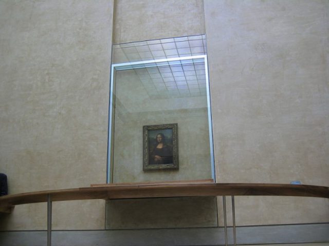 Mona Lisa behind bulletproof glass at the Louvre Museum. Photo by Cayetano CC BY-SA 2.0