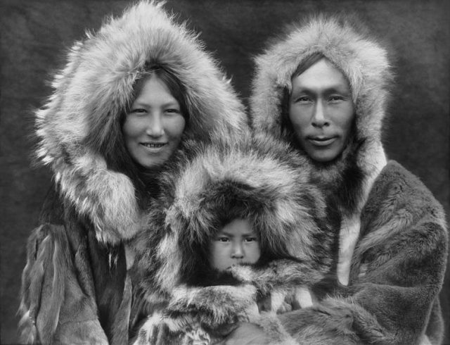 Family portrait of an Inuit family. A mother, father, and their son.