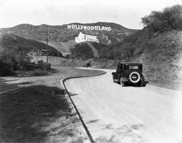Hollywoodland: A sign advertises the opening of the Hollywoodland housing development in the hills on Mulholland Drive overlooking Los Angeles. Hollywood, Los Angeles, California, c. 1924. The white building below the sign is the Kanst Art Gallery, which opened on April 1, 1924. Photo by Underwood Archives/Getty Images