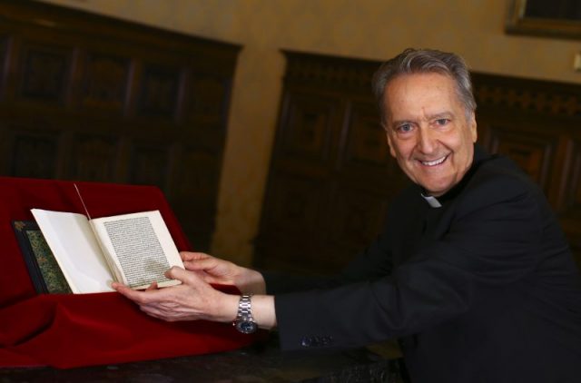 Monsignor Cesare Pasini, chief of the Vatican Library, flips through a letter written by Christopher Columbus that had been stolen from its archives, and returned by the US Homeland Security officials and American ambassador to the Vatican Library. (Photo by TONY GENTILE / POOL / AFP/Getty)