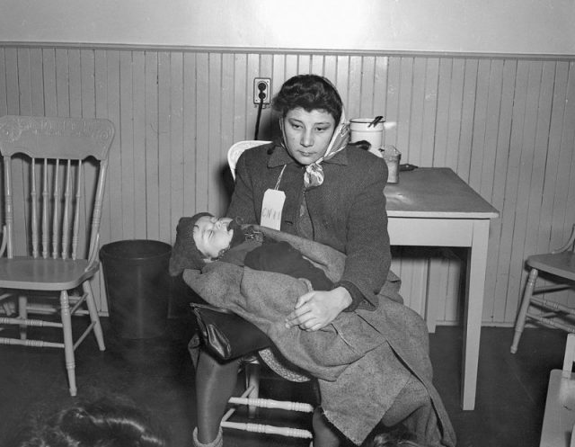 Immigrant woman with baby, Pier 21, Halifax, Nova Scotia, Canada, 1948.